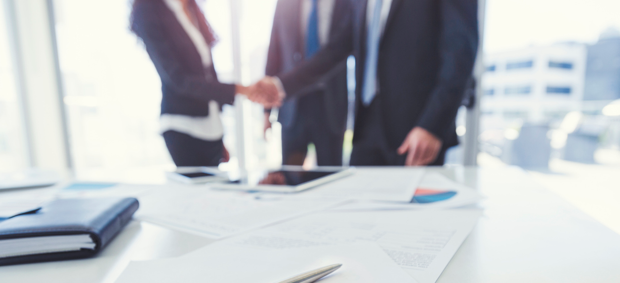 Business-woman-and-business-man-shaking-hands-with-a-contract-edited